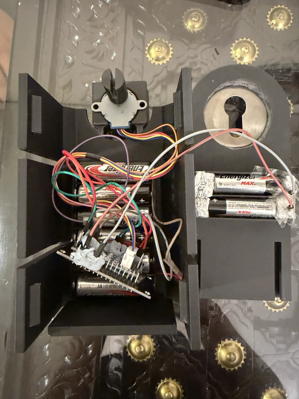 Open automatic door-lock enclosure showing wiring and electronics