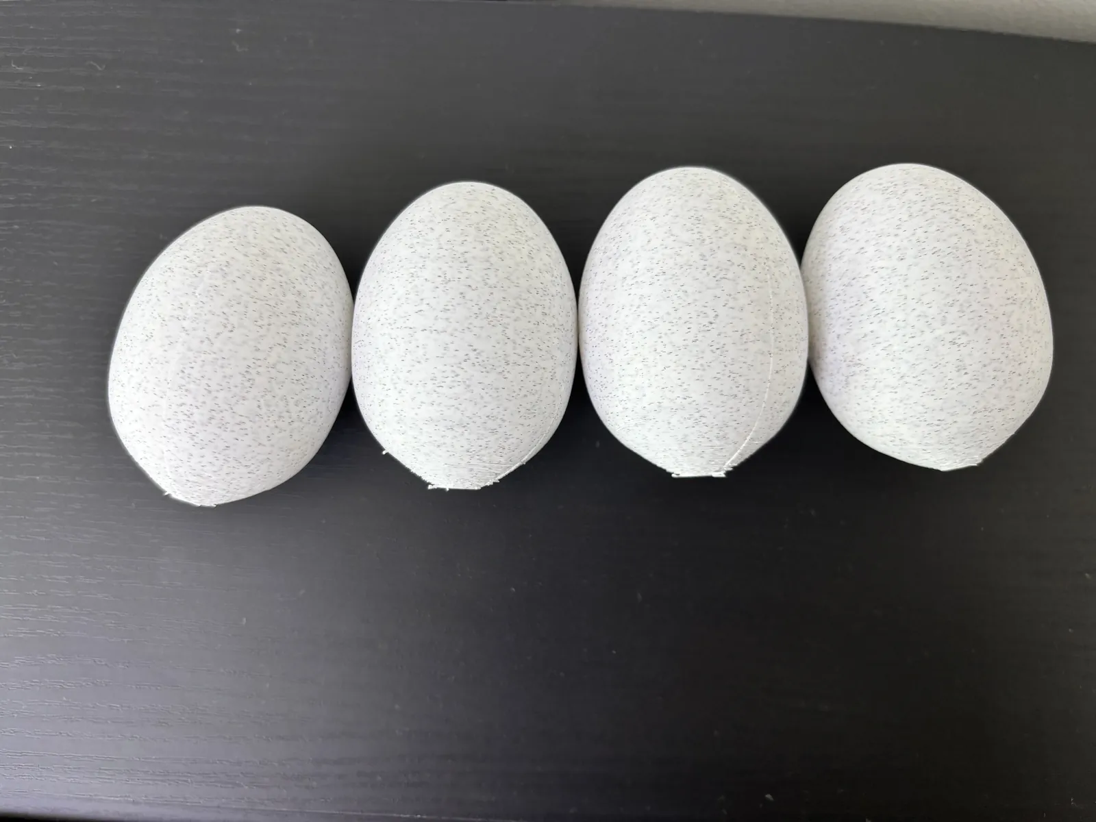 Four white 3D-printed PLA eggs for repeatable Egg Drop testing